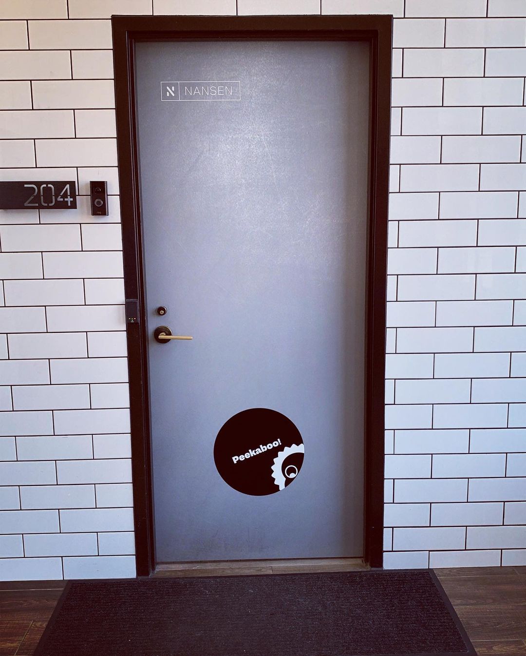 Entrance door in the hallway with logo and Richardo peeking in saying Hi!